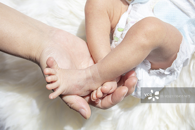 妈妈给新生婴儿抚摸足部图片素材