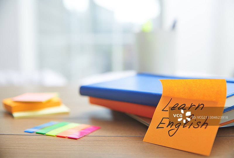 木桌上的橙色“学习英语”便利贴图片素材