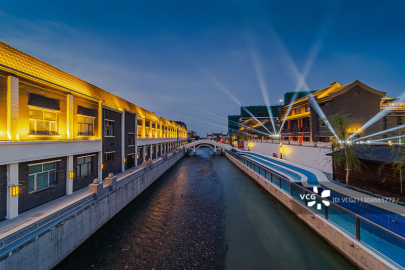 新疆乌鲁木齐米东区地标贡米巷商业步行街河流石头拱桥灯光夜景图片素材