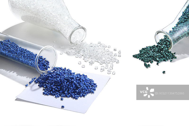 三种颜色的塑料颗粒散落在白色背景上图片素材