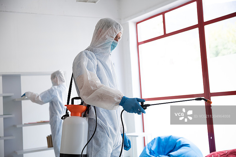 身穿防护服的医护人员使用消毒剂进行清洁图片素材