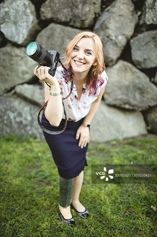 拿着相机微笑的白人截肢女摄影师，美国华盛顿州波尔斯博图片素材