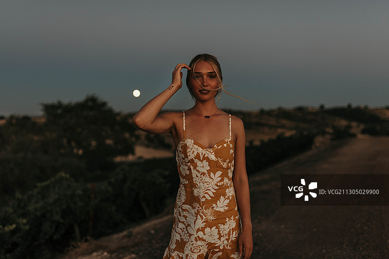 日落时分，头发被风吹起的年轻白人女性肖像，美国加利福尼亚州帕索罗布尔斯图片素材