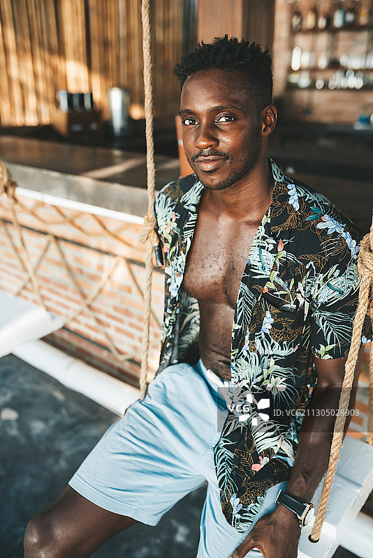 坐在泰国帕岸岛户外咖啡馆的非裔美国男子肖像图片素材