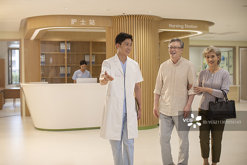 医生与老年夫妇在走廊里交谈图片素材