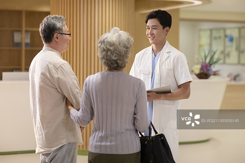 医生与老年夫妇在走廊里交谈图片素材