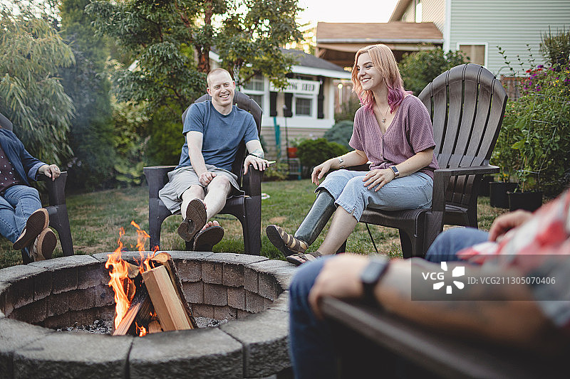 白人女性截肢者与朋友围坐在火炉旁，华盛顿州，美国图片素材