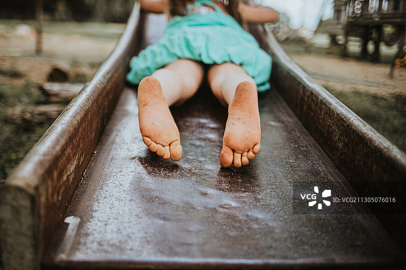 滑滑梯的年轻女孩的脚特写，美国图片素材