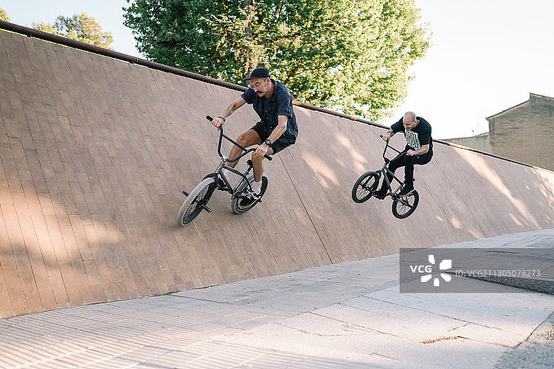 两名白人男子在西班牙的城市中骑BMX自行车图片素材