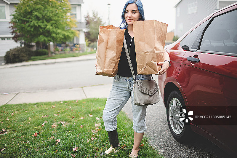 在华盛顿州Poulsbo的汽车旁购物的截肢女人图片素材