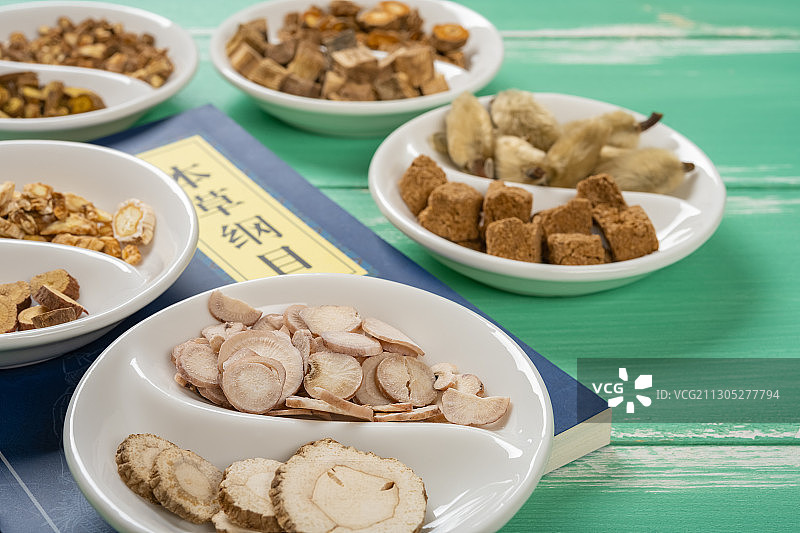 八卦形陶瓷碟子上的多种中药及本草纲目侧视图水平画幅图片素材