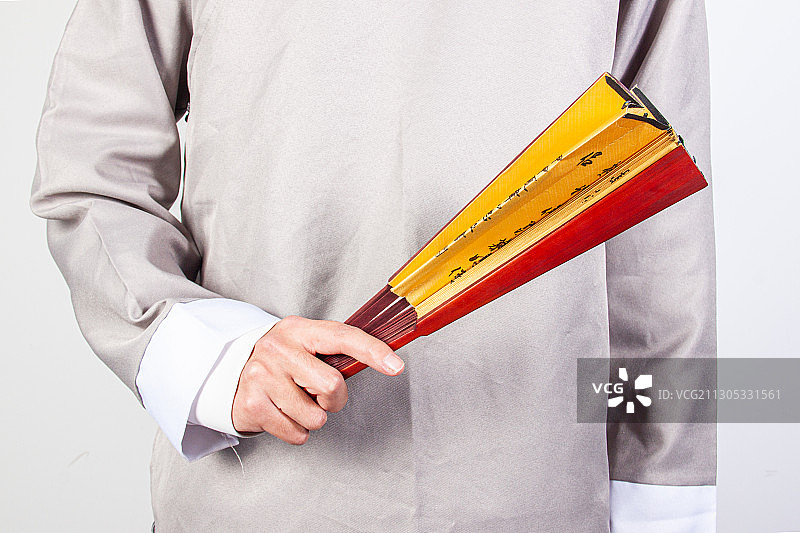 中国传统文化相声表演者穿着古风大褂手持扇子与快板图片素材