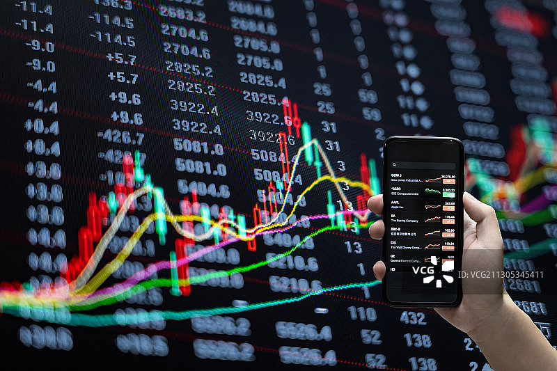 拿着手机看股票和股票证券交易数据分析图片素材