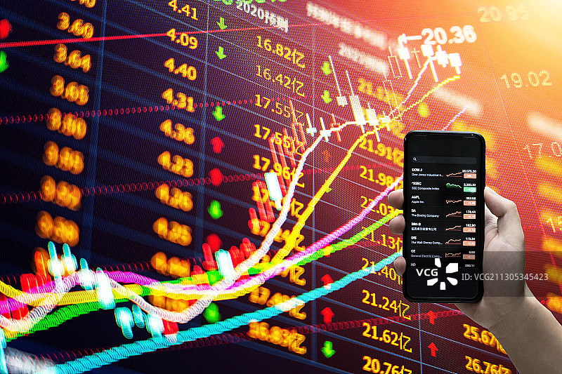 拿着手机看股票和股票证券交易数据分析图片素材