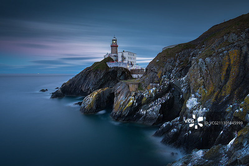 爱尔兰都柏林的百利灯塔，海角，悬崖，日暮时分的冷色调夜景图片素材