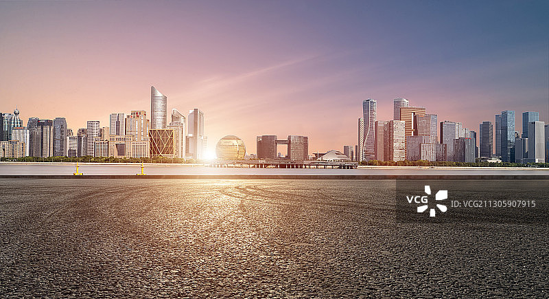 日落时分钱塘江畔的柏油路及对岸的杭州新区建筑群图片素材