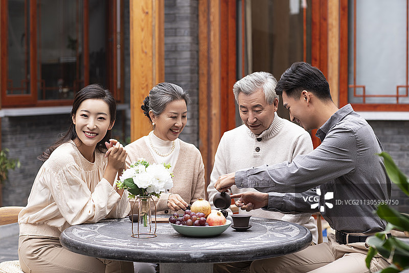 幸福的一家人在院子喝茶聊天图片素材
