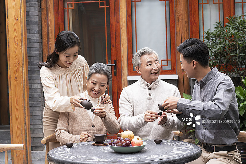 幸福的一家人在院子喝茶聊天图片素材