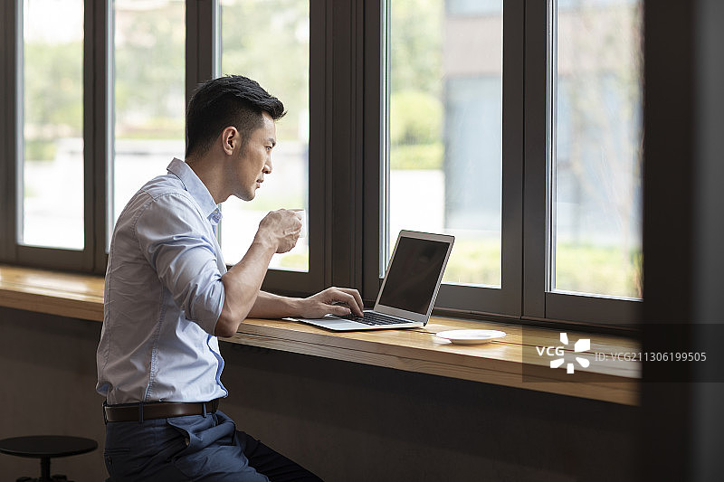商务男子在咖啡馆使用笔记本电脑工作图片素材