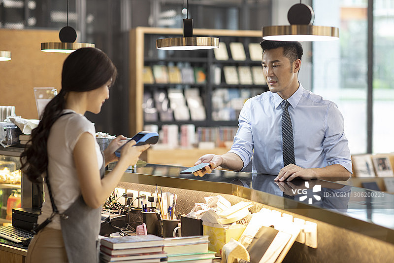 商务男士在咖啡馆用手机结账图片素材