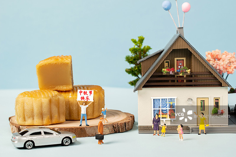 中秋节房子旁边的月饼人群聚集在一起举牌中秋节快乐图片素材