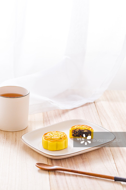 放在长方形瓷盘里的切开的中国传统点心月饼图片素材