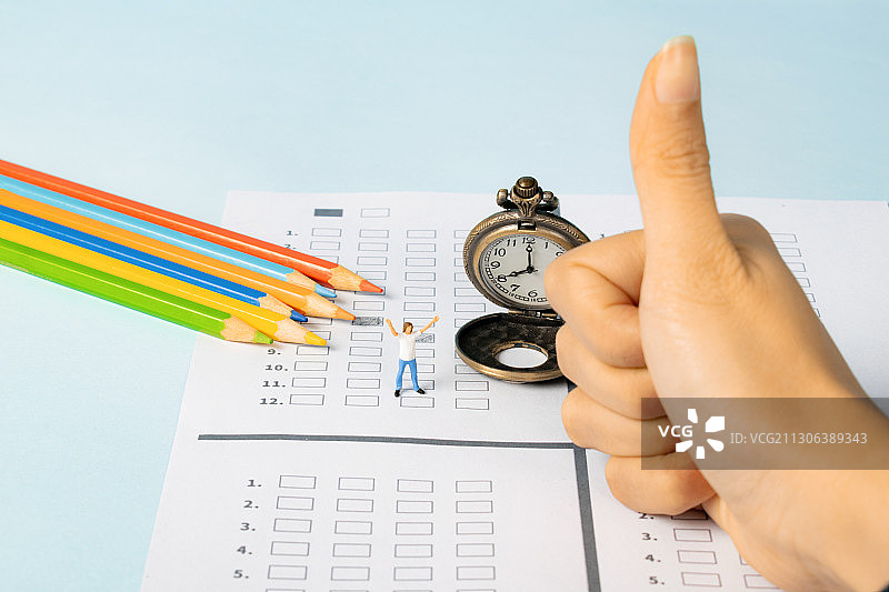 学生在桌上填写答题卡闹钟旁边欢呼准备考试信心十足图片素材