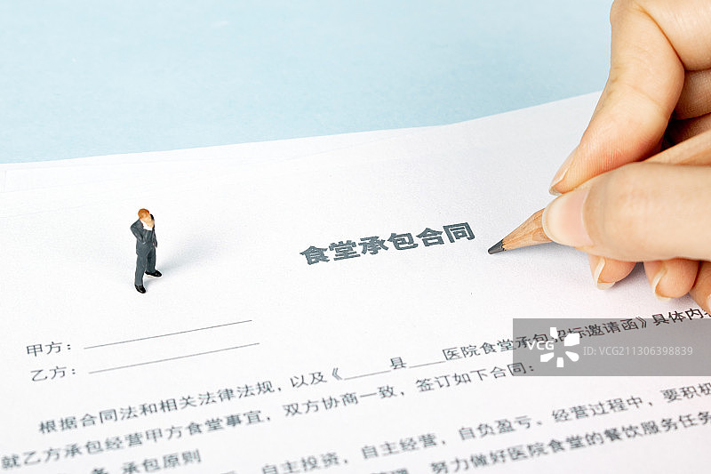 在纸上填写思考食堂承包合同图片素材