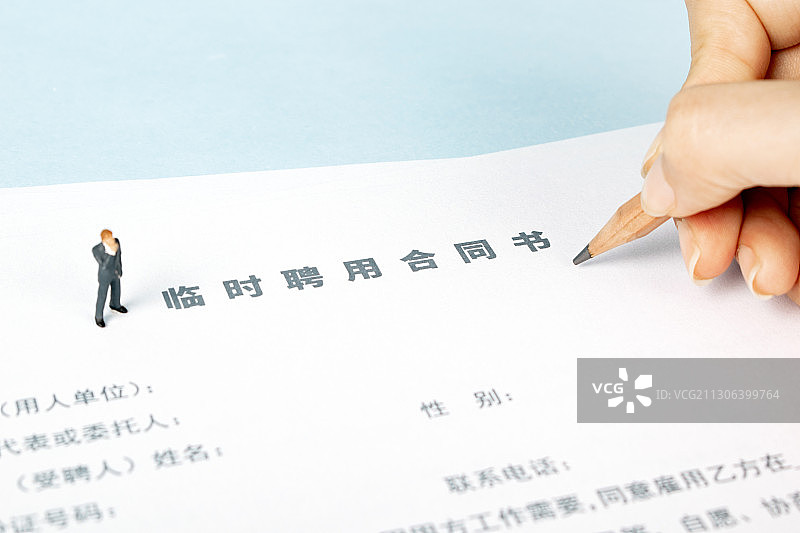在纸上填写思考临时聘用合同书图片素材