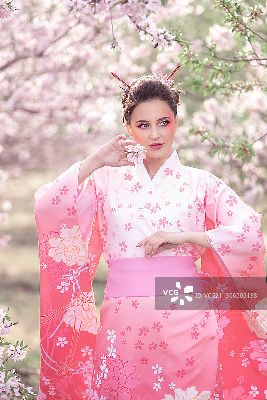 身穿和服站在樱花树旁的女人，保加利亚布尔加斯图片素材