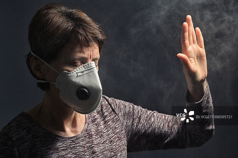 在黑色背景下戴着医用口罩的女人图片素材