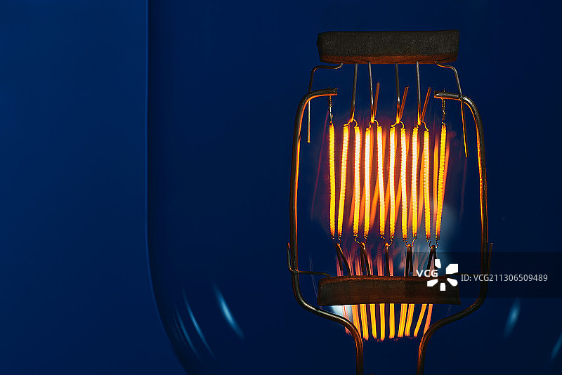 蓝色背景下的高功率白炽灯钨丝图片素材
