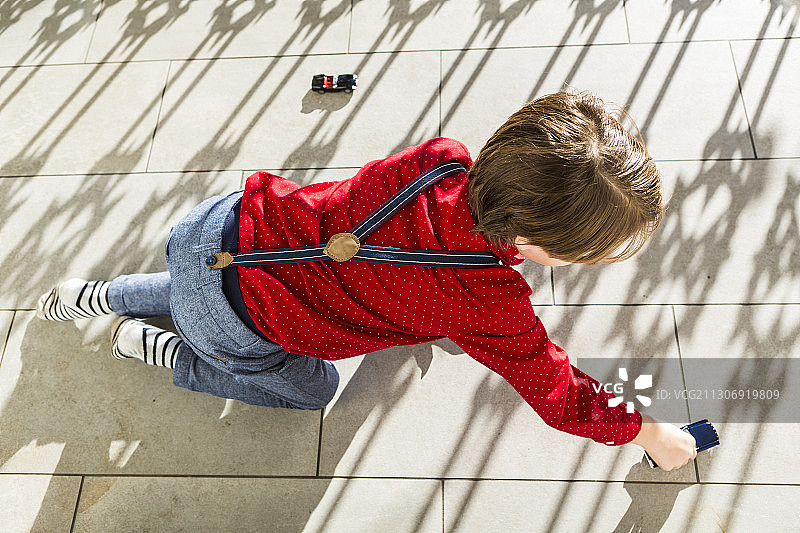 6岁男孩在露台上玩玩具车图片素材