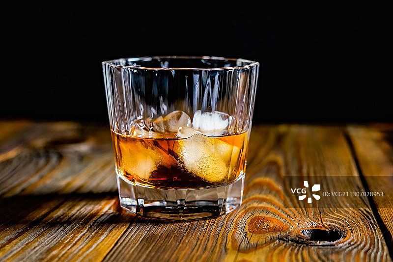 黑色背景下桌上威士忌酒杯特写图片素材