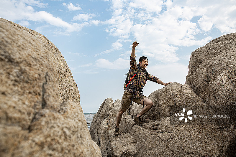 青年男子在户外攀岩探险欢呼图片素材