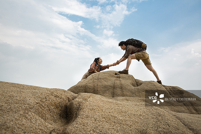 青年情侣户外做攀岩运动图片素材