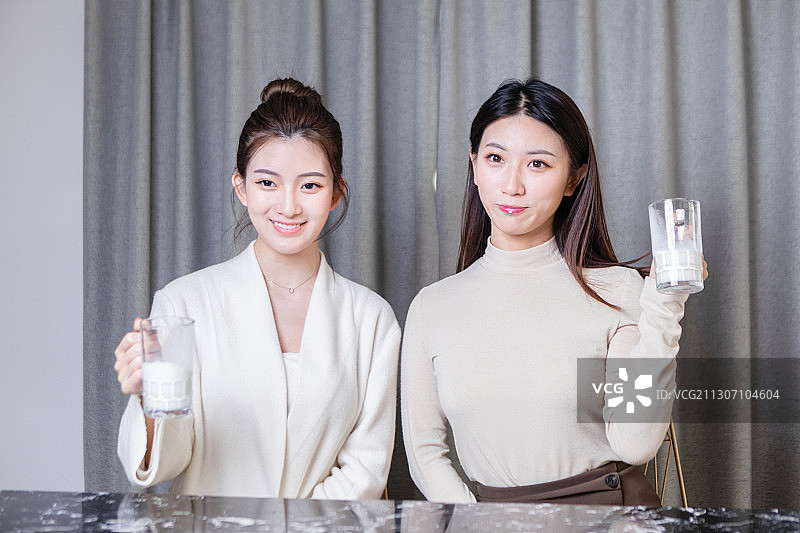 正在喝牛奶的两位美女图片素材