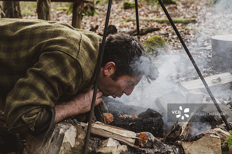 男子在森林里生篝火图片素材