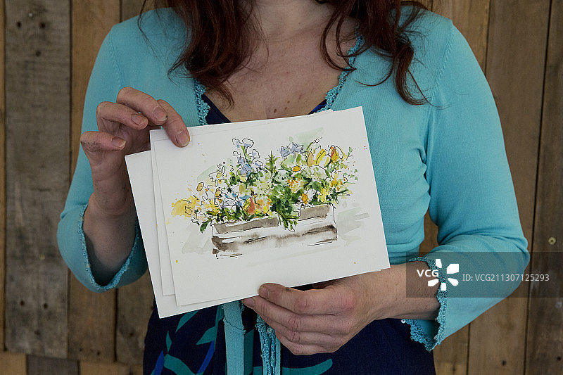 在命名仪式上手持花卉画作的女人图片素材