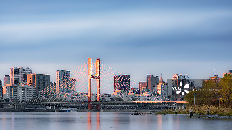 吉林市江滨公园遥望临江门大桥，河道清洁工在工作图片素材