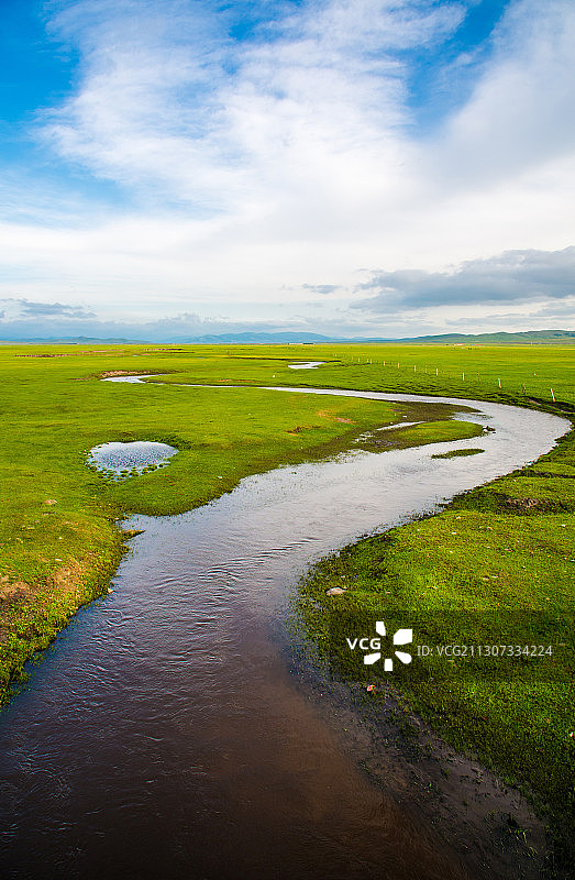 蜿蜒的河流穿过一望无际的草原图片素材