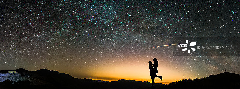 银河拱桥下相拥的情侣图片素材