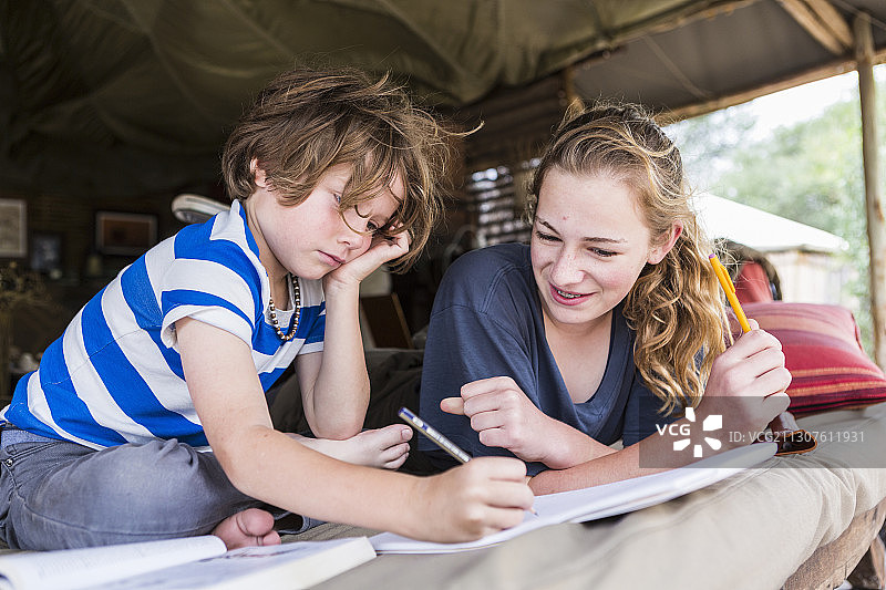 兄妹在博茨瓦纳帐篷营地一起做作业图片素材
