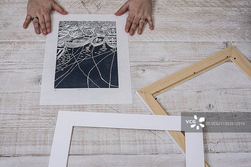 一个人将油毡版画装入画框图片素材