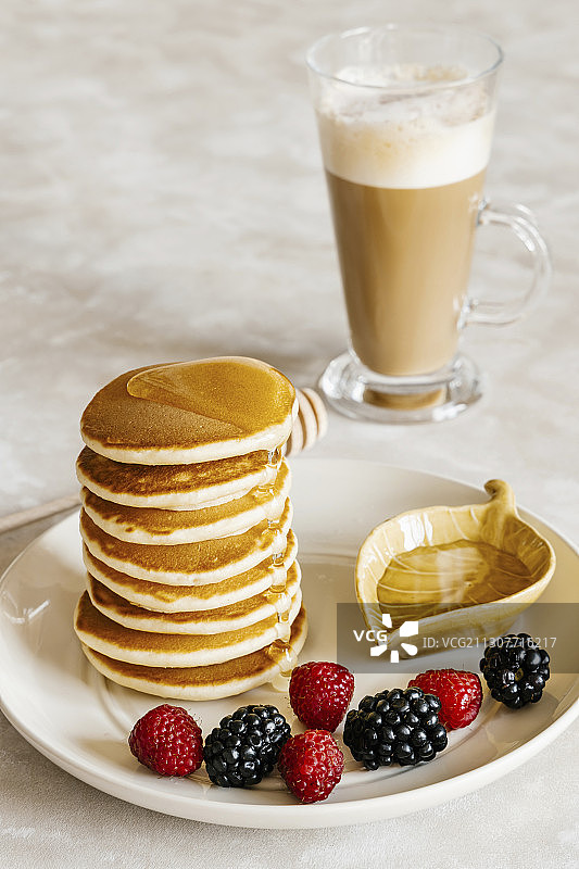 薄煎饼配蜂蜜覆盆子黑莓和拿铁图片素材