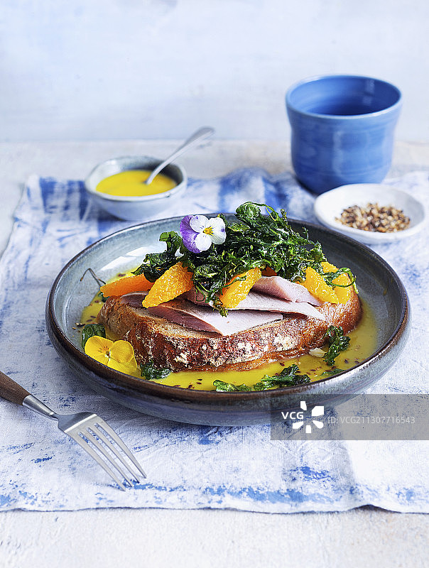 配有腌鲱鱼、橙子和黄油酱的香草沙拉面包片图片素材