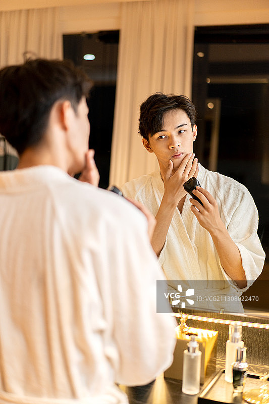 在酒店客房刮胡子的差旅人士图片素材