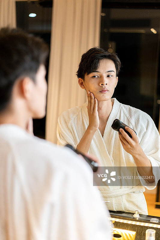 在酒店客房刮胡子的差旅人士图片素材
