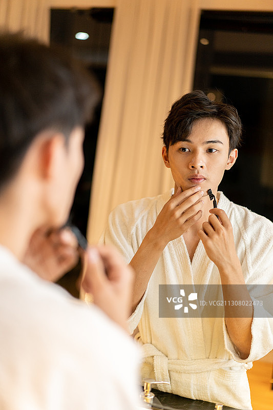在酒店客房刮胡子的差旅人士图片素材