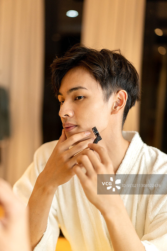 在酒店客房刮胡子的差旅人士图片素材